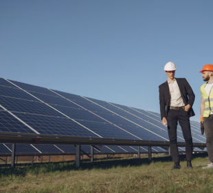 Businessman and engineer discussing solar energy solutions at a solar panel installation site.